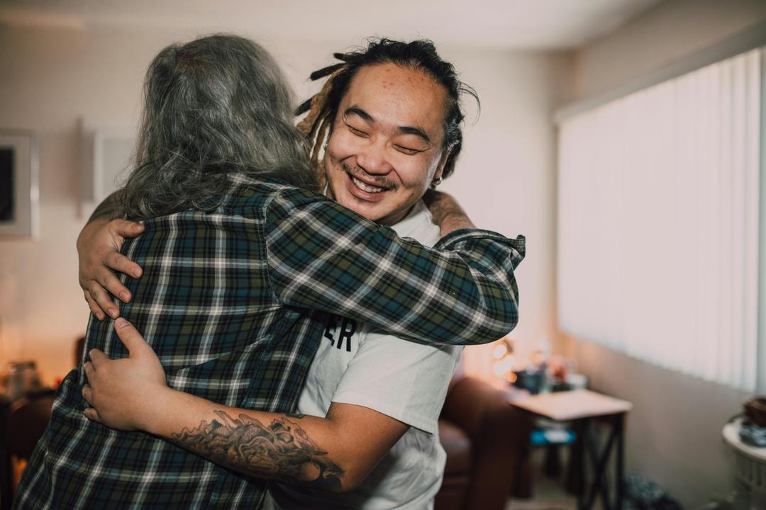 A volunteer embracing a community member outside a relief centre.