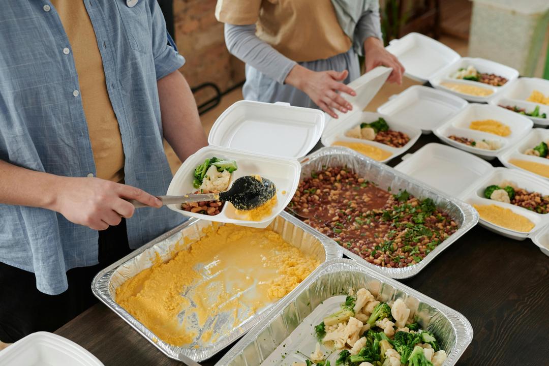 Volunteers packing food hampers together at a community hall.